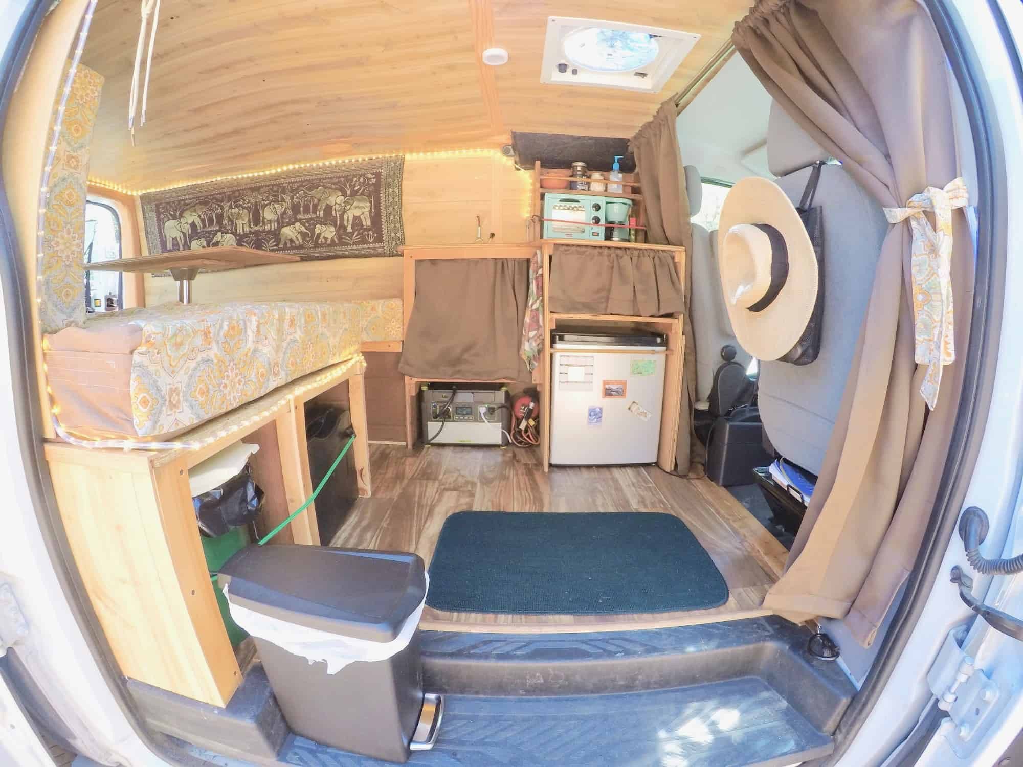 Van interior with blackout curtains and tension rods