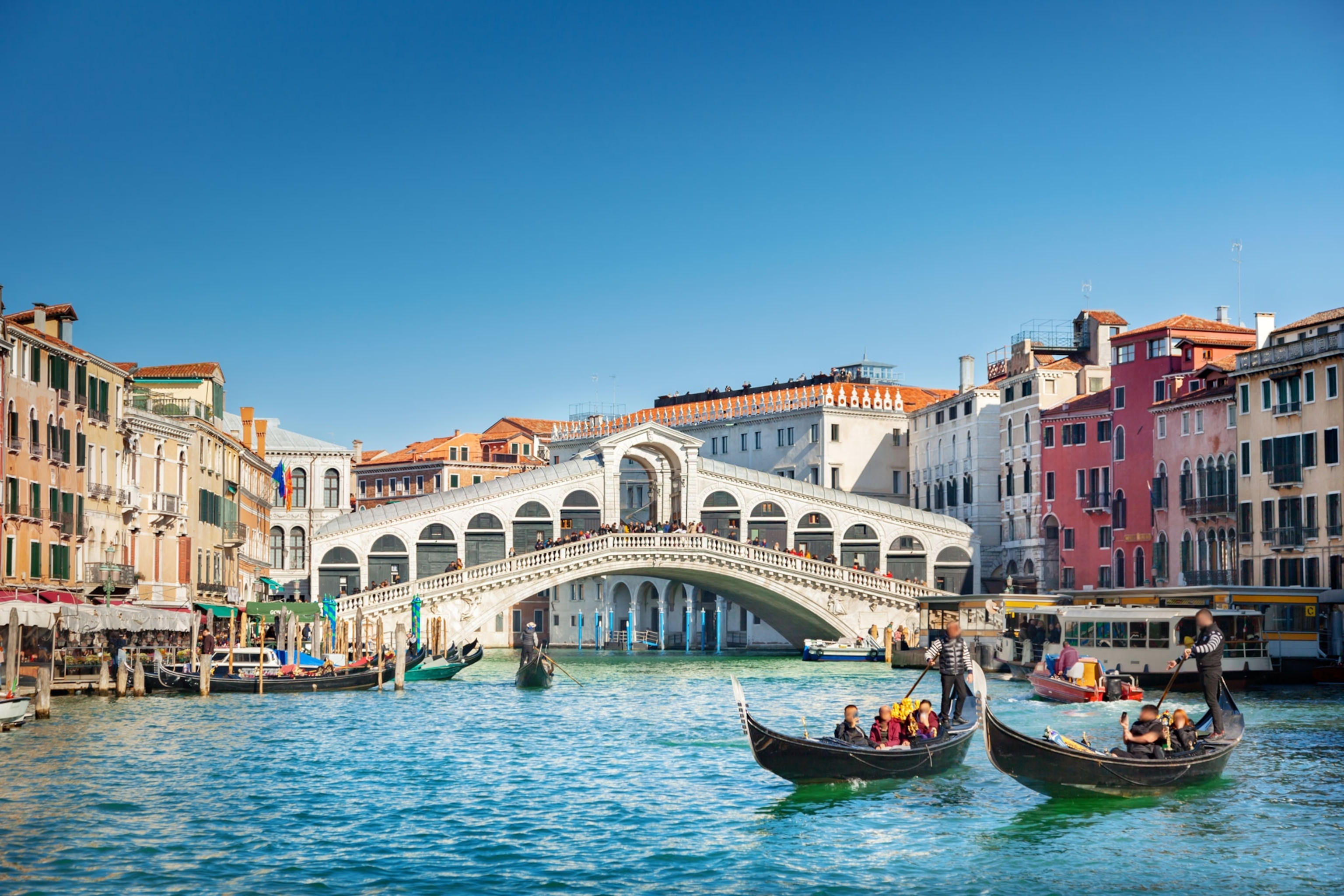 A bridge stands over a canal with boats on the water