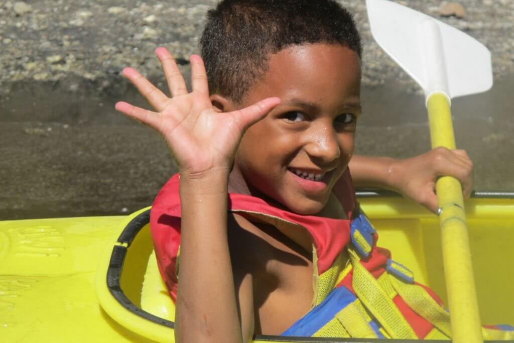 A boy in a canoe on a lake, symbolizing family-friendly activities in Plumas County