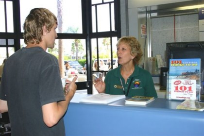 A Travelers Aid Volunteer Helps a Visitor at the Airport