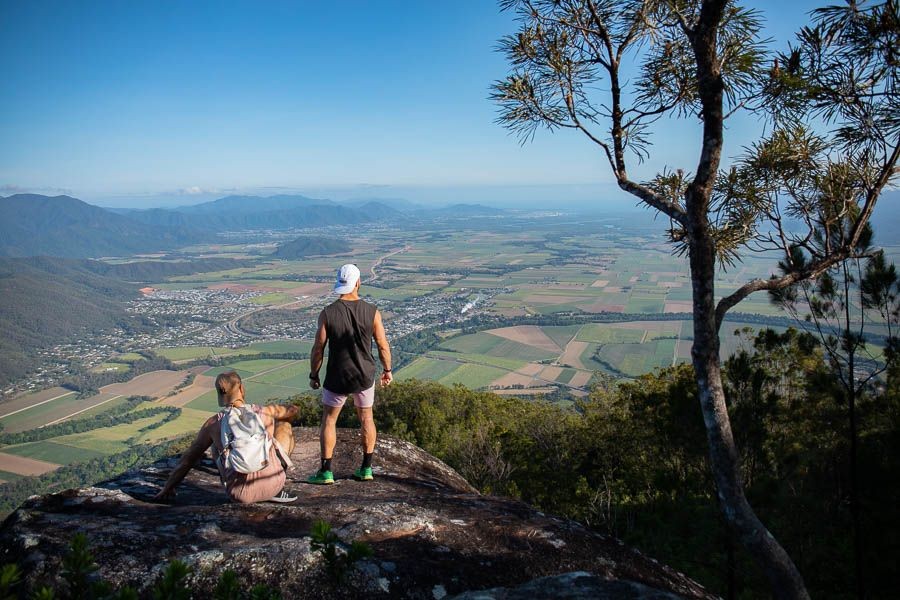 Adventurers gazing at the Cairns landscape from atop a mountain