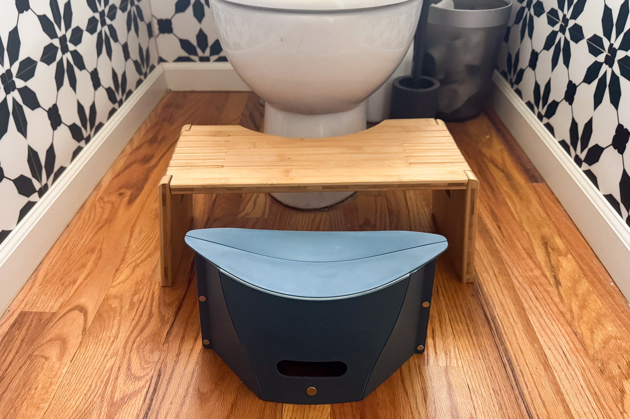 The Folding Portable Camping Hiking Stool set up in front of a Squatty Potty in front of a toilet seat.