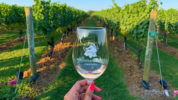 Woman holding Wolffer Estate Vineyard wine glass