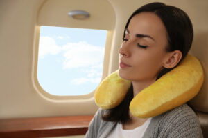 Woman using a travel pillow sleeping on a plane