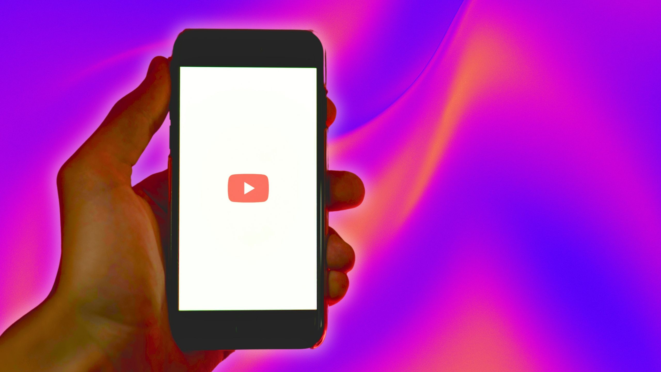 iPhone displaying YouTube on a colorful background