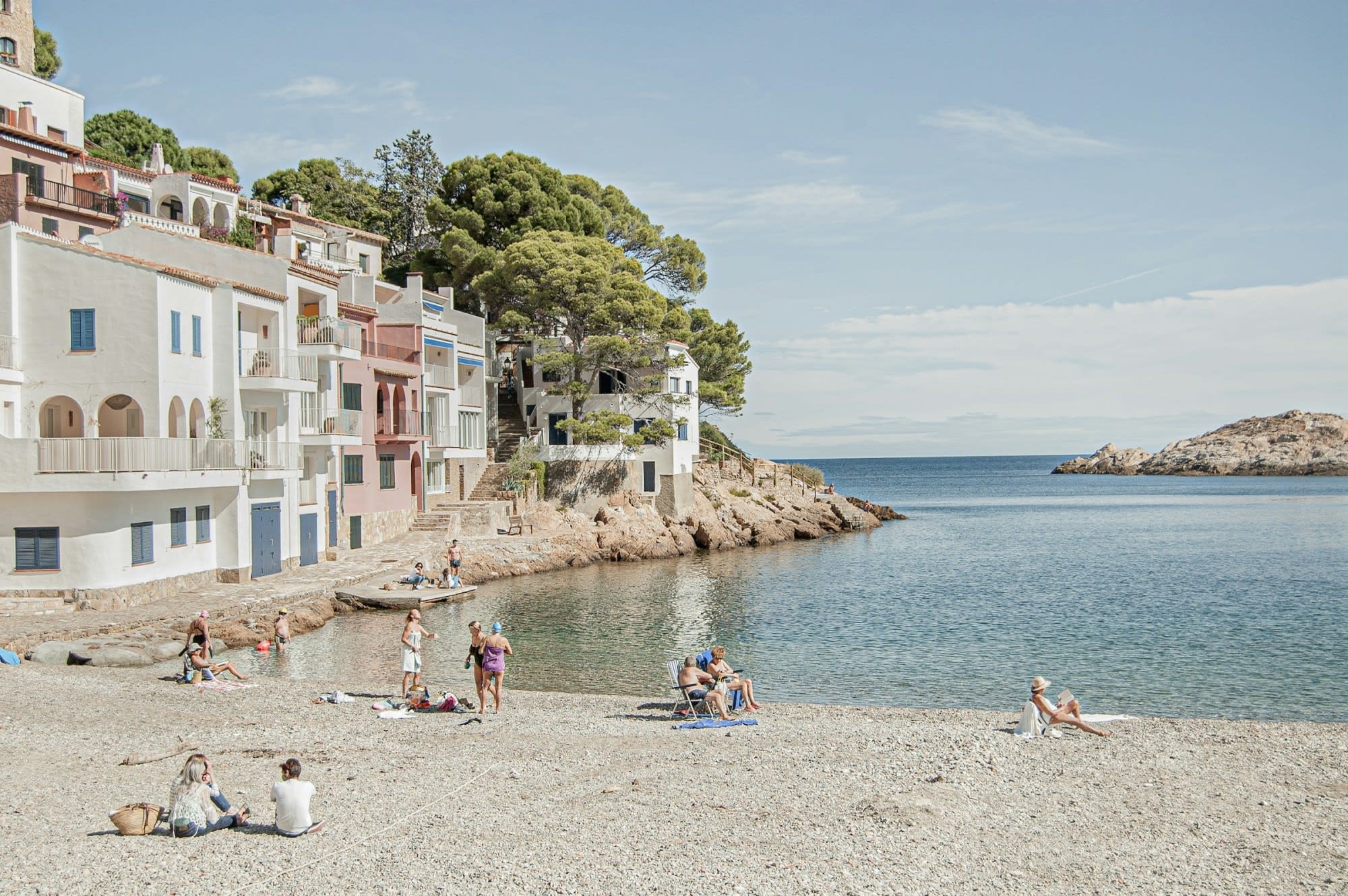 Relaxing beachgoers enjoying calm waters near historic buildings, representing travel destinations